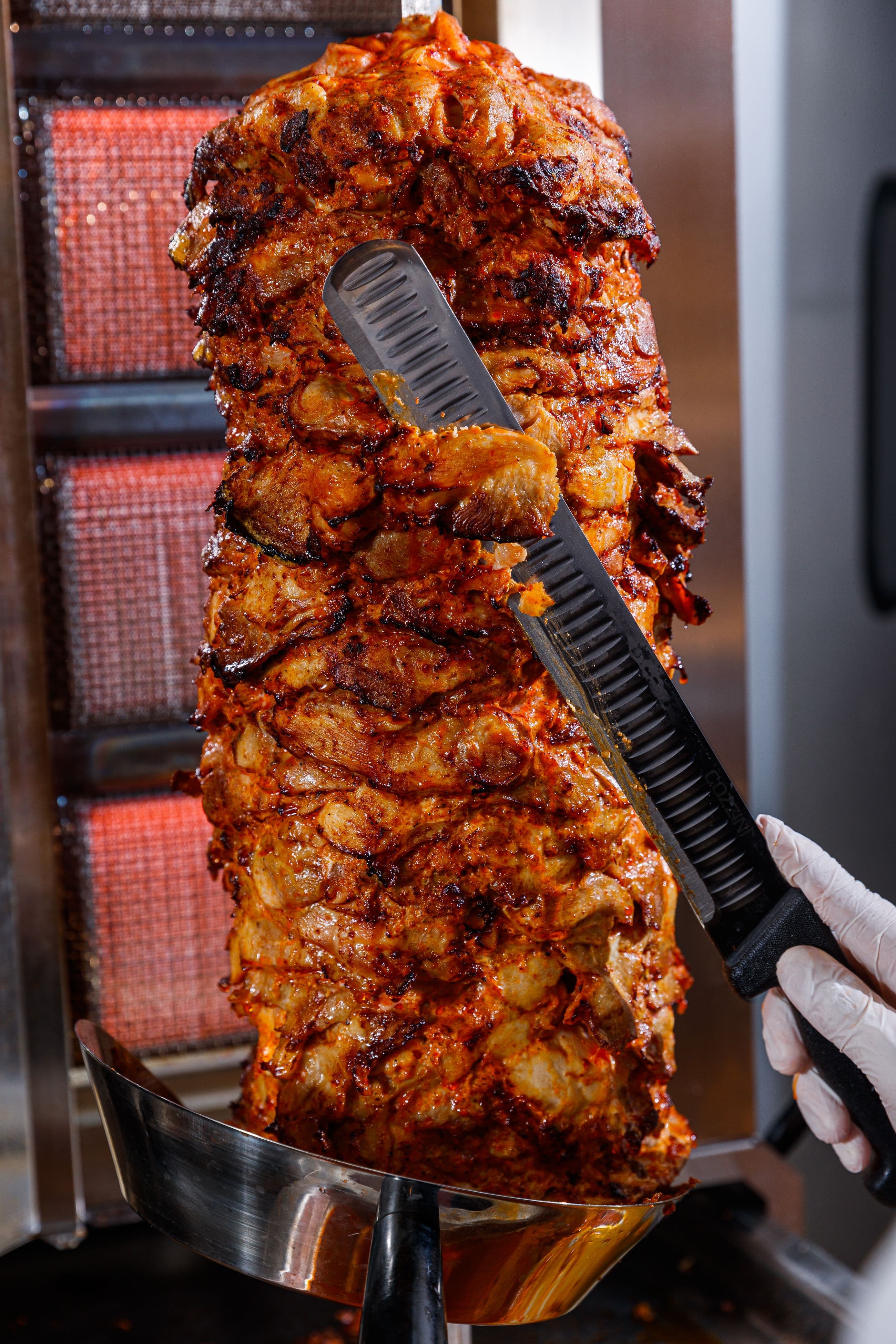 Chicken shawarma being carved from the spit at Pita Melt